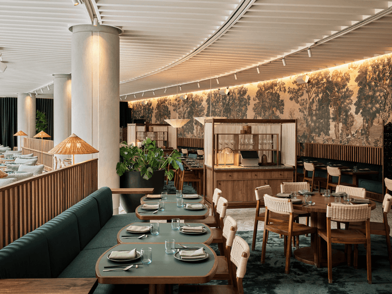 Elegant dining room with wooden tables and chairs set for a seafood banquet.