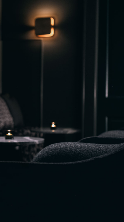 A private dining room with charcol gret chairs with dim lighting.