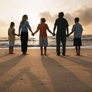Family holding hands at the beach near Cala Luna Boutique Hotel