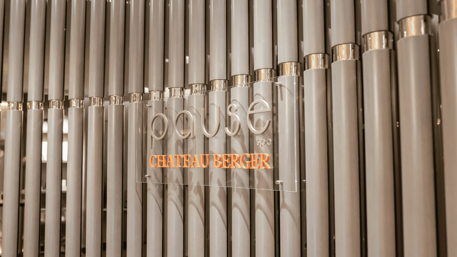 Stylish sign for pause spa Chateau Berger against a modern, vertical-lined wall at Paramount Hotel Midtown