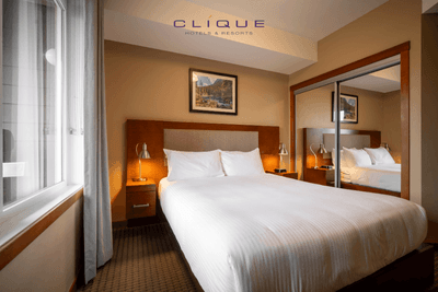 Bright and cozy bedroom at Falcon Crest Lodge features a comfortable king-size bed, bedside lamps, and a window