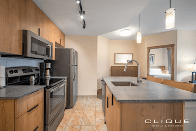 Kitchen in a suite at Falcon Crest Lodge features stainless steel appliances and a breakfast bar with seating