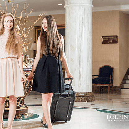Two ladies with two suitcases at Delfines Hotel