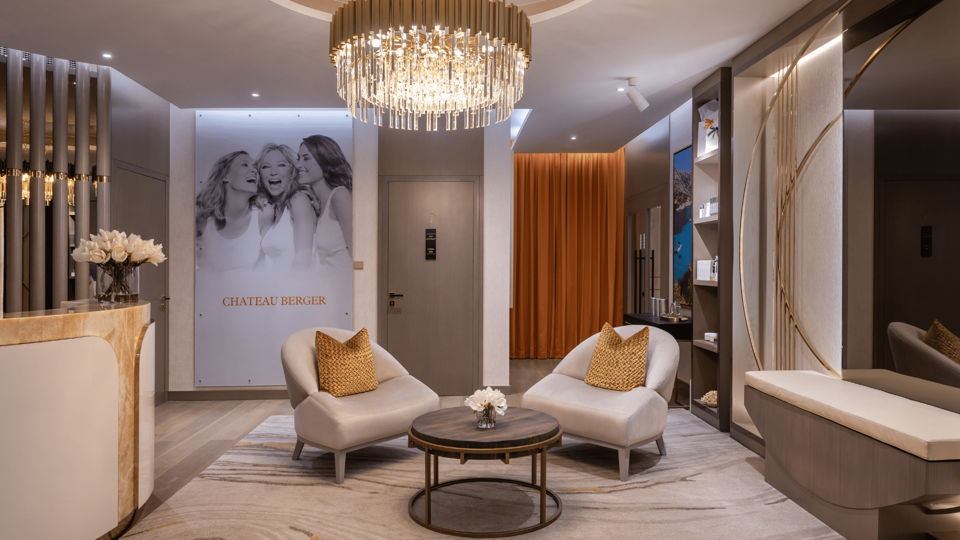 Spa lounge with comfortable armchairs, a round coffee table, and a dazzling crystal chandelier at Paramount Hotel Midtown