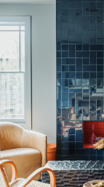 Priviate event space with a blue tiled fireplace and cream colored chairs