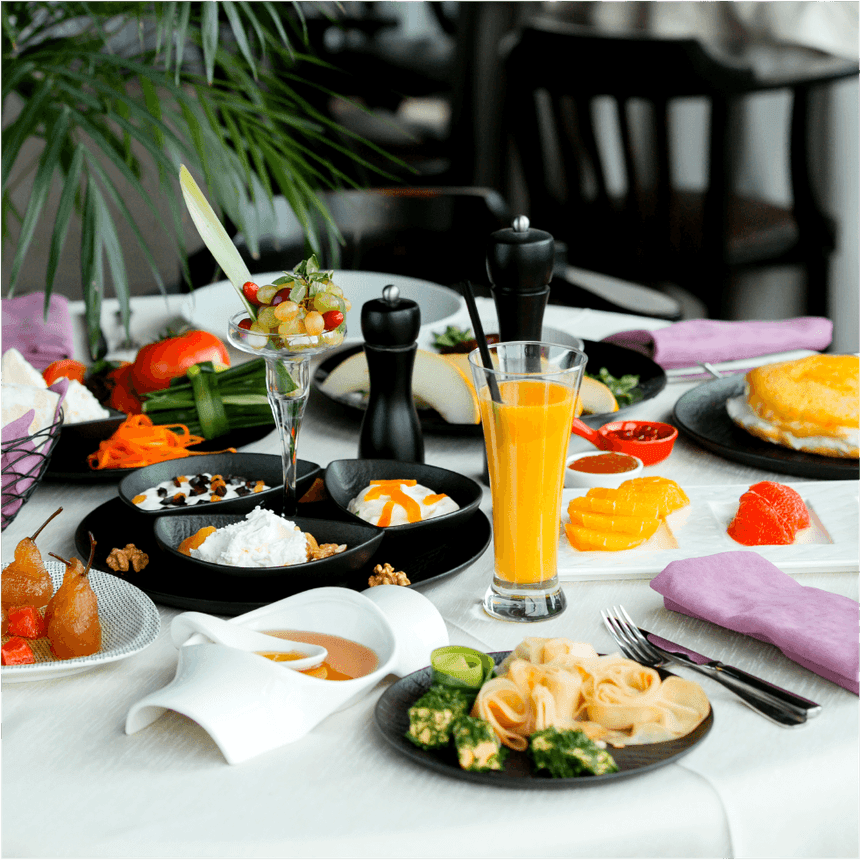 Desayuno con fruta, yogur y zumo de naranja junto a molinillos de pimienta en Megapolis Hotel Panama