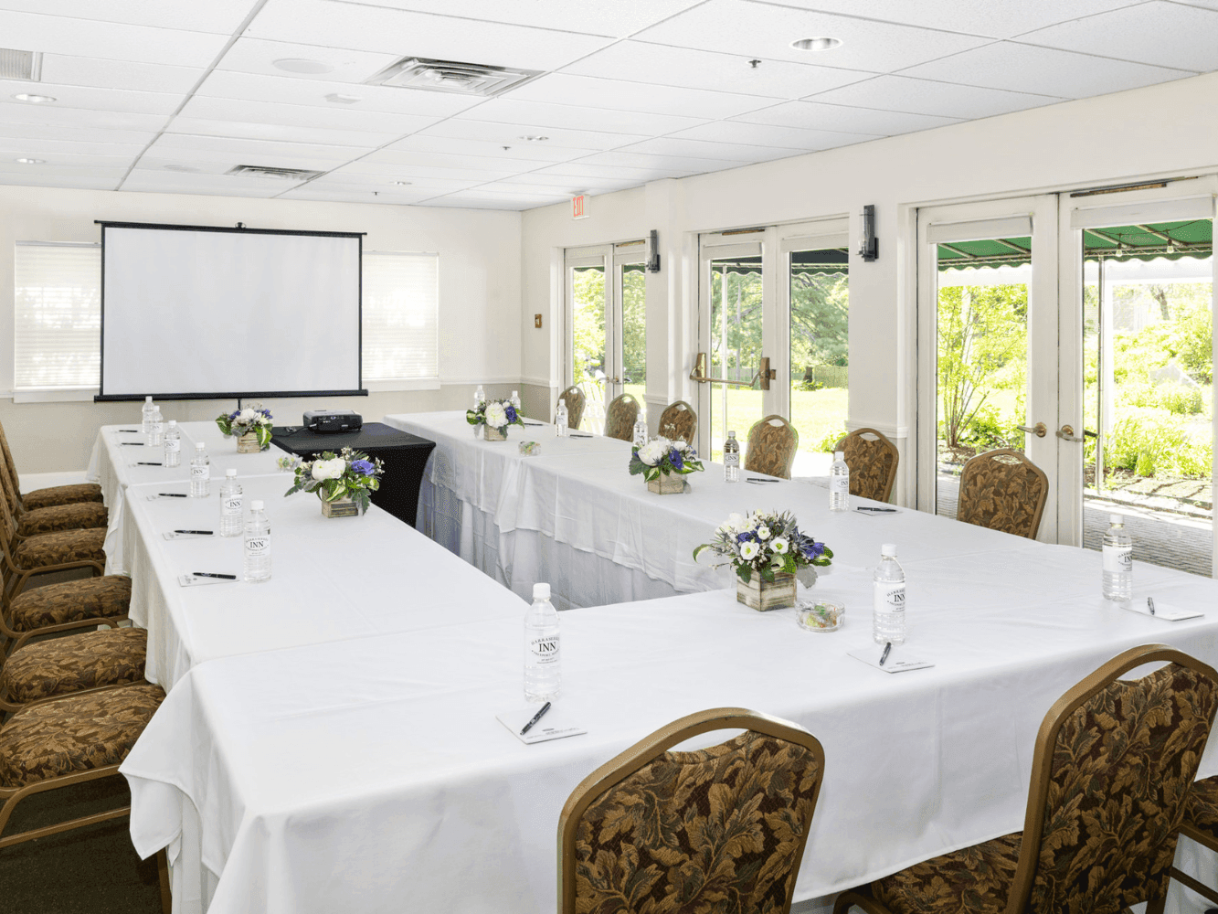 U shaped meeting set up with flower decor in Androscoggin Room at Harraseeket Inn