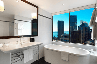 Bath tub by the window in a bathroom at Amora Hotel