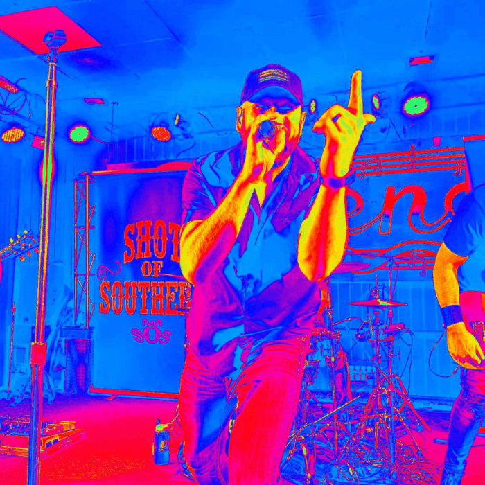 Shot of Southern band at ICONA Windrift this Summer - blue red & yellow photo 3 men with microphone and guitars on stage