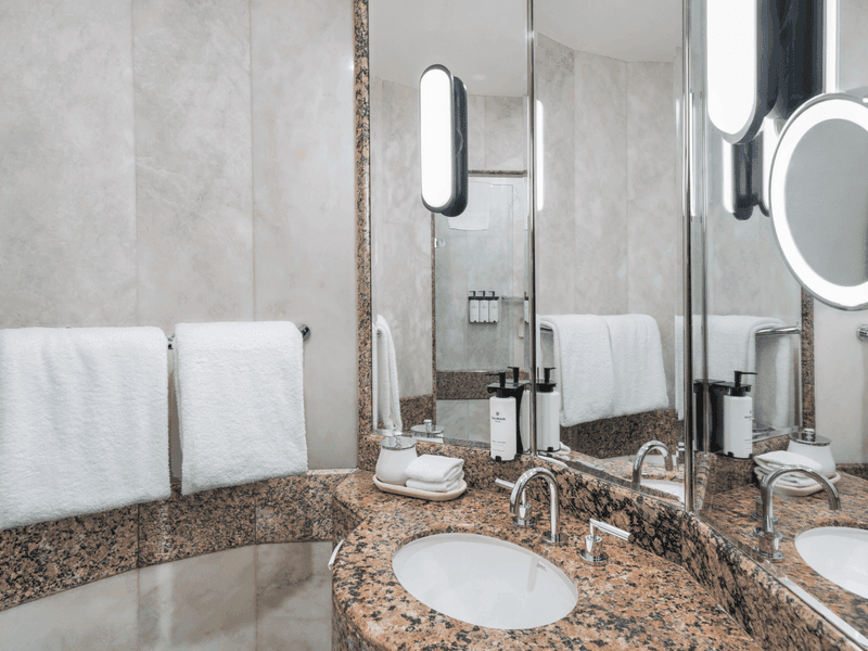 Luxury hotel bathroom with granite vanity, undermount sink, large mirror and premium amenities