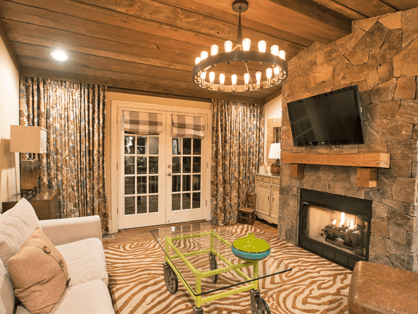 Interior view of Overlook East Cozy living room with a stone fireplace, wooden ceiling in Inn at Willow Grove