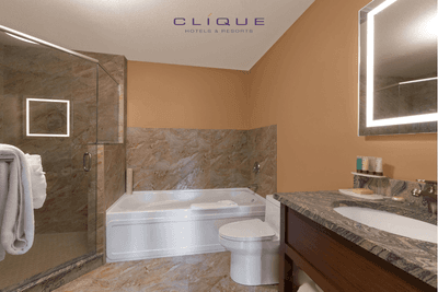 Well-lit bathroom in a suite at Falcon Crest Lodge features a combined shower and bathtub, a toilet