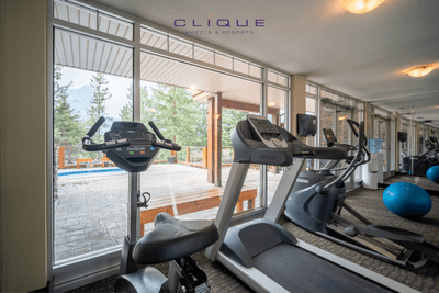 Fitness center at Falcon Crest Lodge features treadmills, an elliptical machine, and a view of the outdoor hot tub area