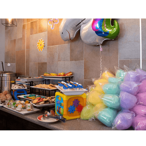 Dessert table with cupcakes and cookies beside cotton candy bags & a unicorn balloon in Palmira Cafeteria at Araiza Calafia
