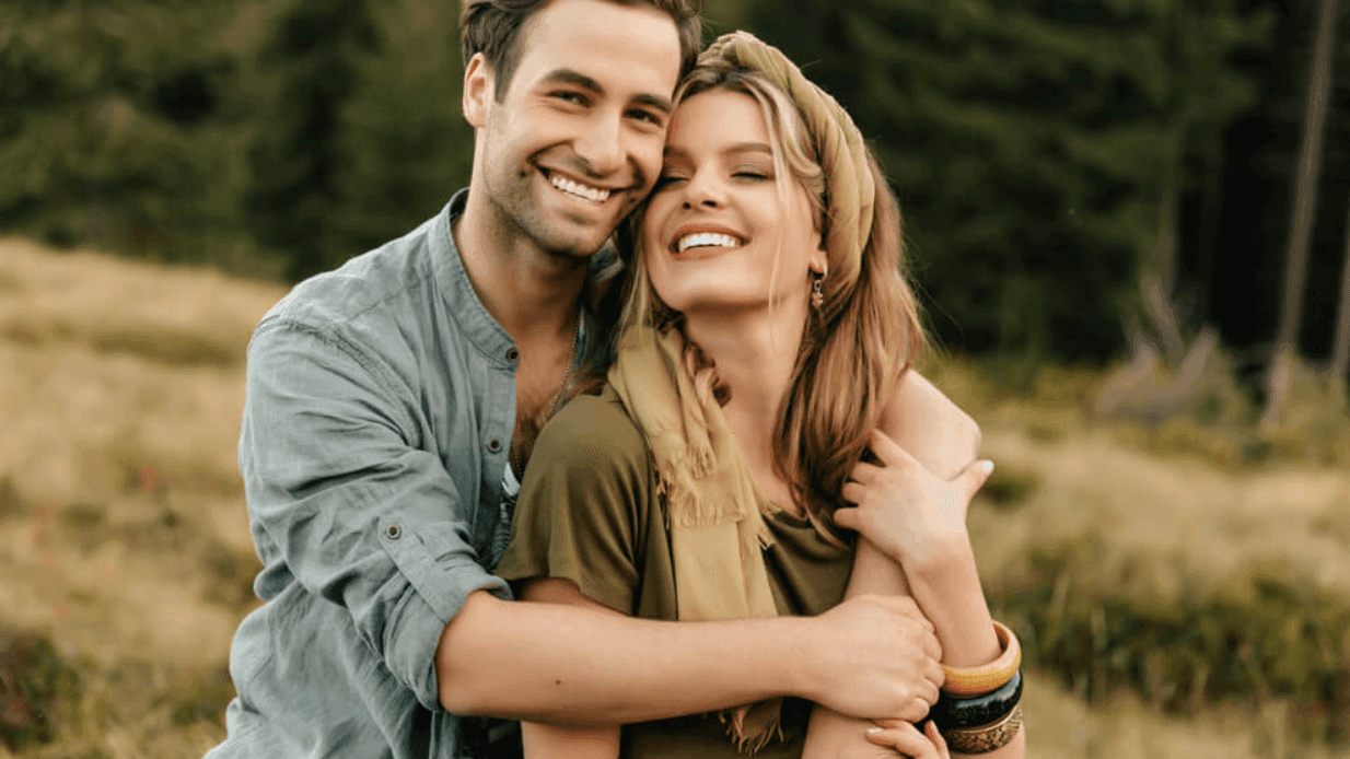 Couple hugging on a field in the evening, featuring capturing love at Cove Pocono Resorts