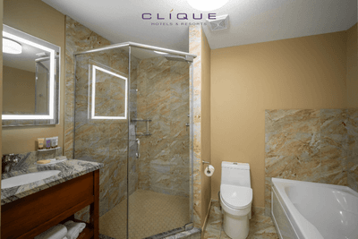 Modern bathroom in a suite at Falcon Crest Lodge features a glass-enclosed shower, a separate bathtub