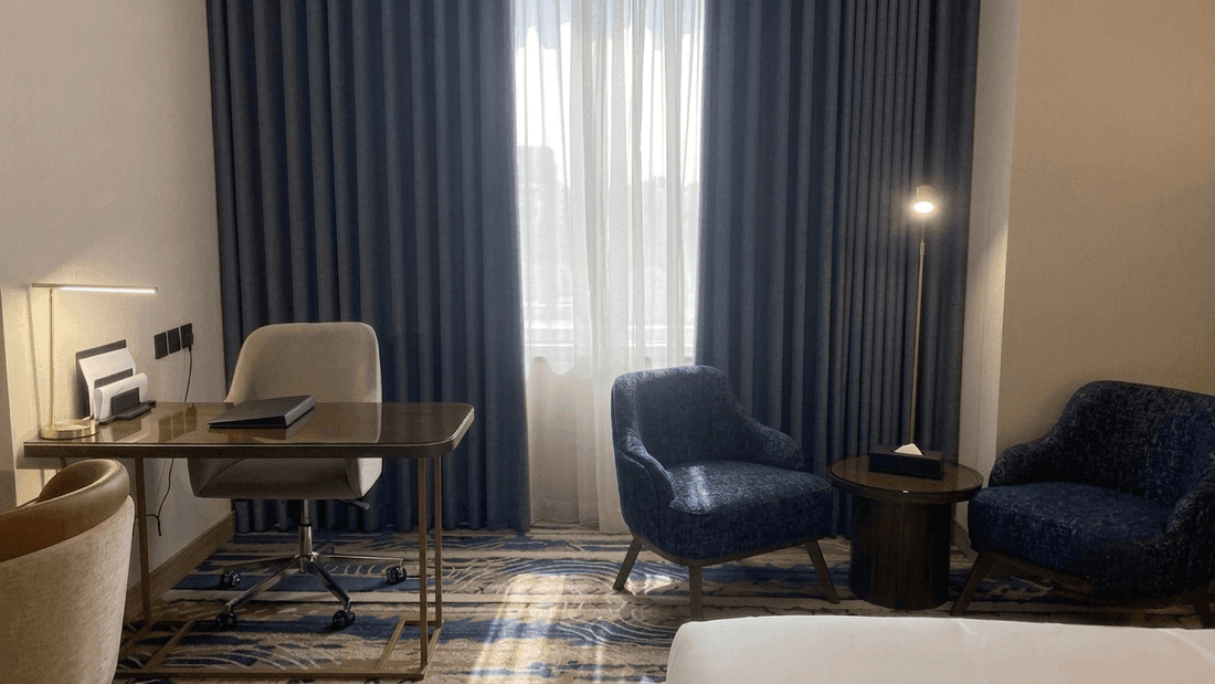 Accessible Room King with work desk, blue armchairs, and floor lamp at Warwick Hotel & Spa - Jeddah.