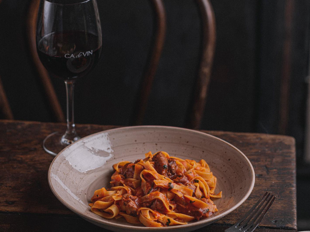 Pasta & wine glass served in Ca de Vin restaurant at Brady Hotels Central Melbourne