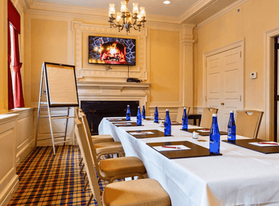 Meeting room with boardroom set-up, TV, and carpeted floors at The Exeter Inn