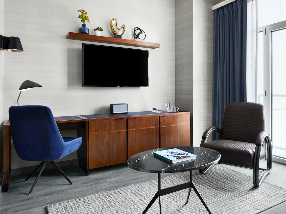 Living Room in Manhattan Suite with a table, chairs and a TV at Gansevoort Meatpacking NYC