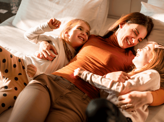 Mother laying on bed with her kids at Hotel Plaza San Francisco