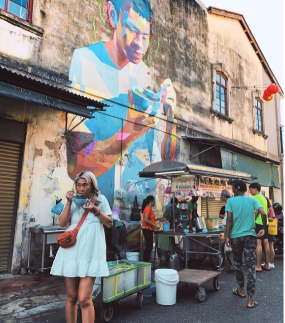 penang local street food in front of a mural