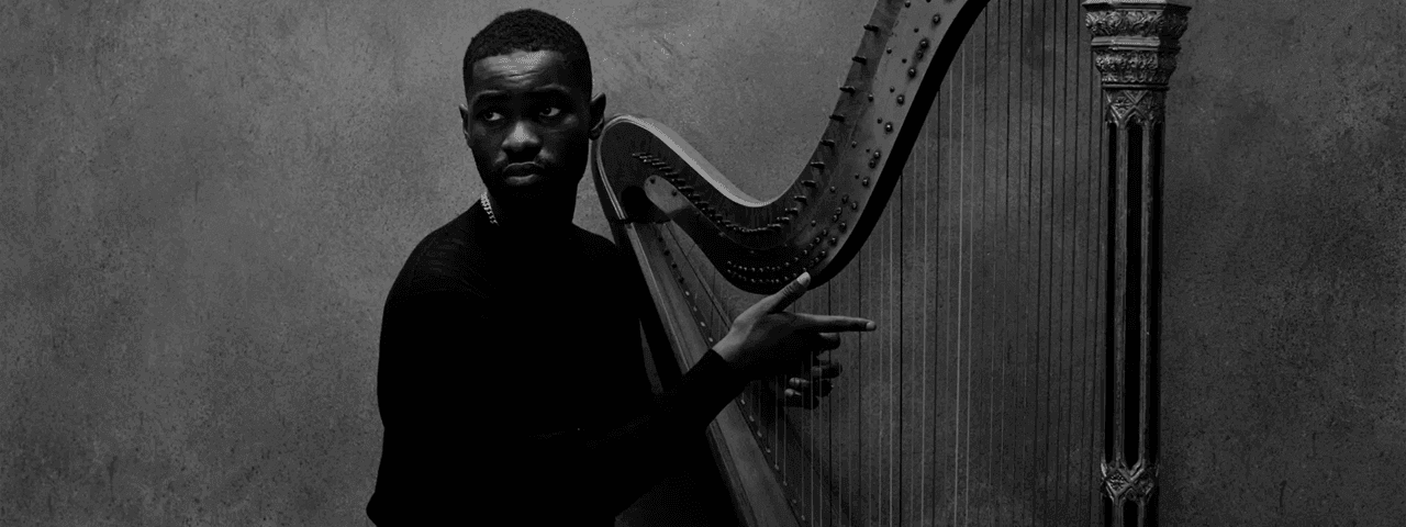 A man posing with a harp for the Dave - The Boy Who Played the Harp Tour 2026.