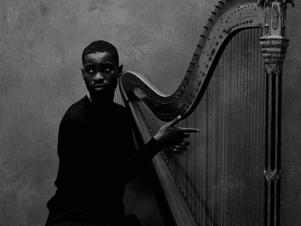 Man pointing to harp in black and white image for Dave - The Boy Who Played the Harp 2026 event.