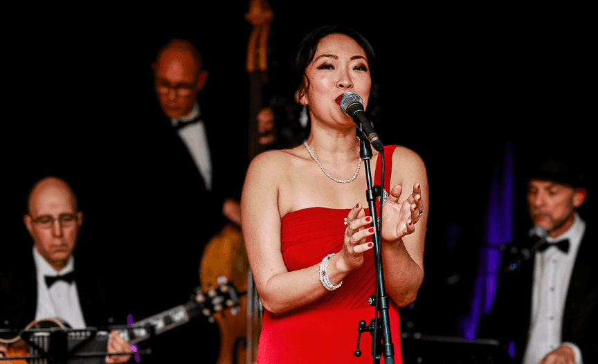 Lady singing on a stage at an indoor event in Hotel Eldorado