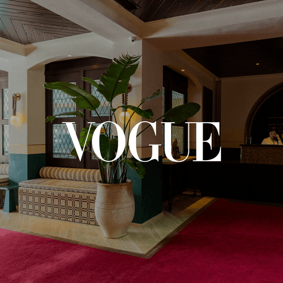 Hotel lobby with large plant, red carpet, and 