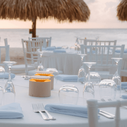 Beachside Christmas dinner setup with festive menu and Christmas tree on left side.