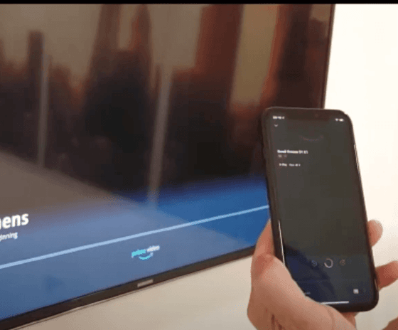 Hand holding a smartphone by a smart TV screen at Paramount Hotel Seattle