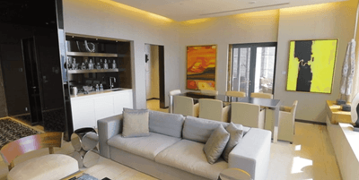 Livingroom area with cozy sofa, abstract art, and dining table in Lotus Apartments at One Farrer Hotel