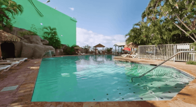 Swimming pool beside palm trees at Emerald Beach Resort, tropical escapes at top St. Thomas resort with pool facing the ocean