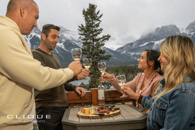 Group of four toasts with wine on a balcony, enjoying a cheese board and a stunning mountain view at Falcon Crest Lodge