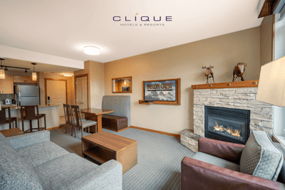 Living area in a suite at Falcon Crest Lodge features a comfortable sofa, armchairs by a fireplace, a dining table