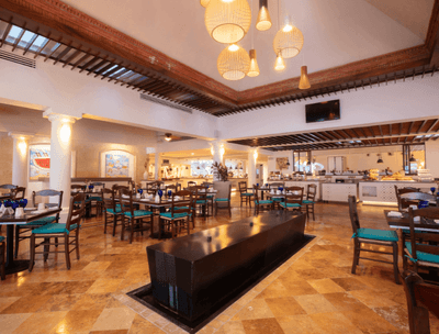 Frutas y Flores Restaurant interior with dining tables, TV and buffet area at Buenaventura Grand Hotel and Spa