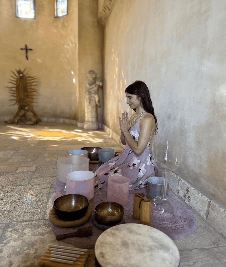 Lorem ipsum Women knealing on floor surrounded by sound healing instruments