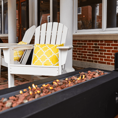Outdoor patio with sets of patio furniture next to fire pits at The Exeter Inn
