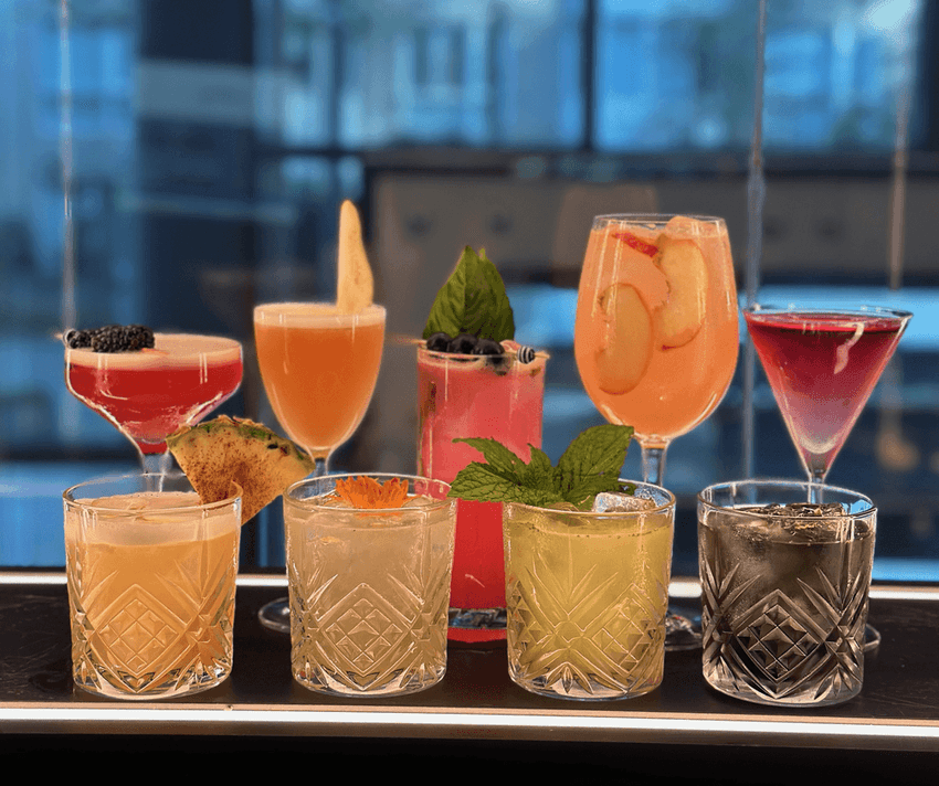 Various cocktails with garnishes on a bar counter from Paradox Vancouver.