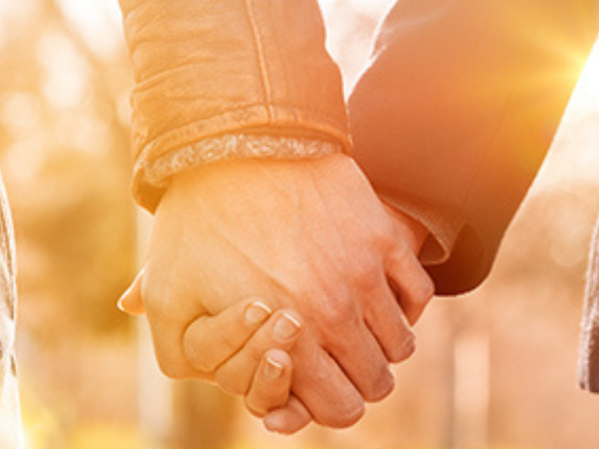 Closeup on couple holding hands at Wolfeboro Inn during sunset