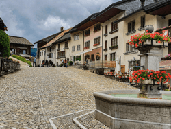 Aerial view of a Medieval city of Gruyeres nestled among rolling hills near Hotel des Innovations