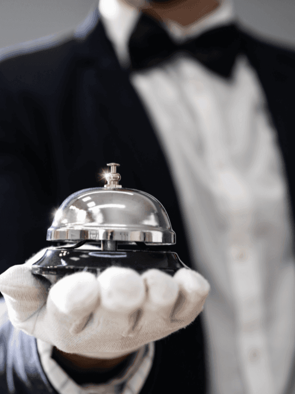 Concierge tenant une cloche à l'Hôtel Westminster Paris.