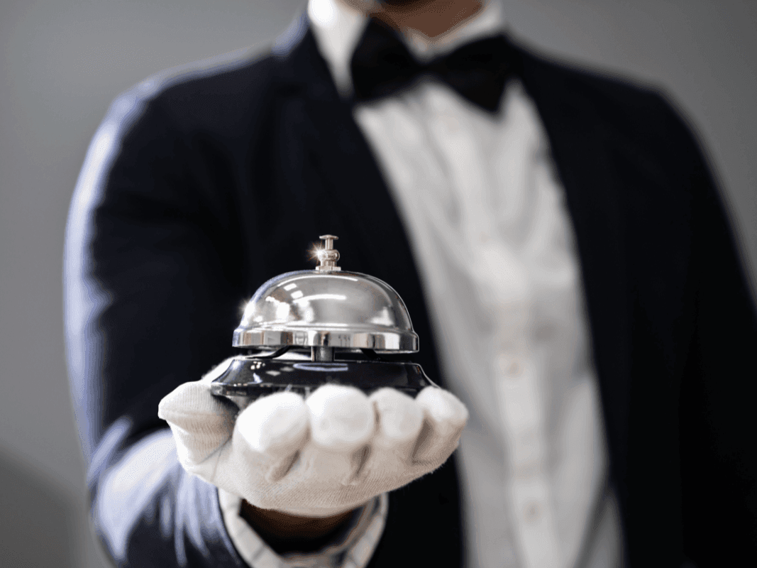 Concierge tenant une cloche à l'Hôtel Westminster Paris.