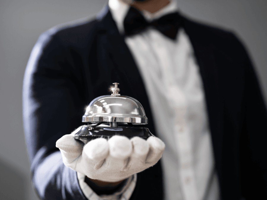 Concierge tenant une cloche à l'Hôtel Westminster Paris.
