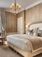 Bed with an ottoman and couch near the window in Executive Room at Hotel Westminster Paris