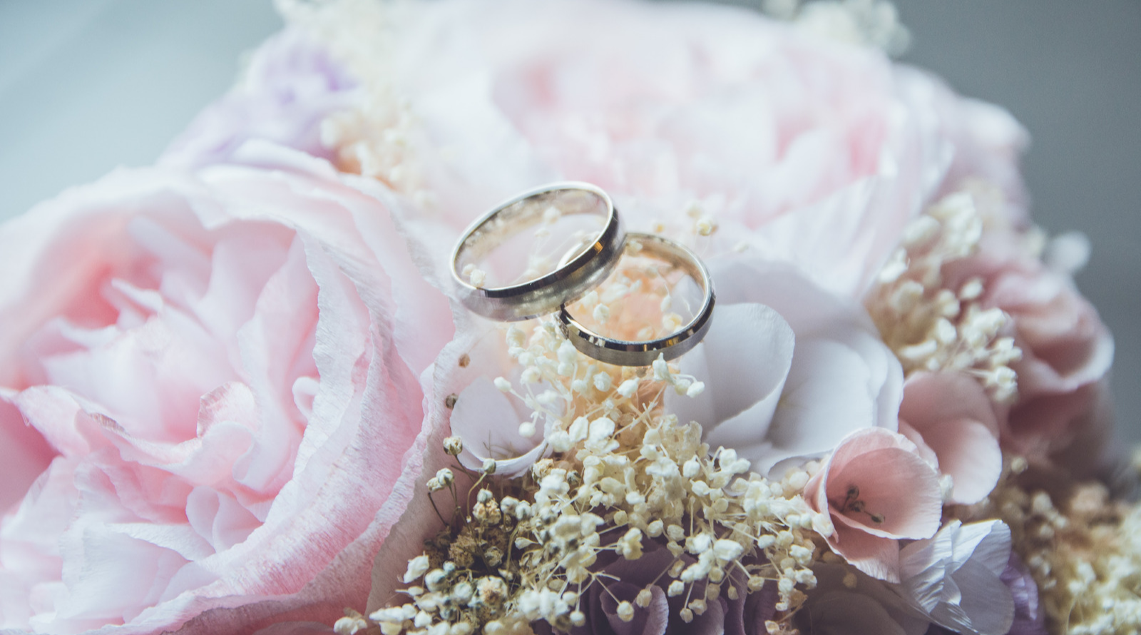 Two wedding rings resting on a bouquet of pink flowers at Fullerton Sydney