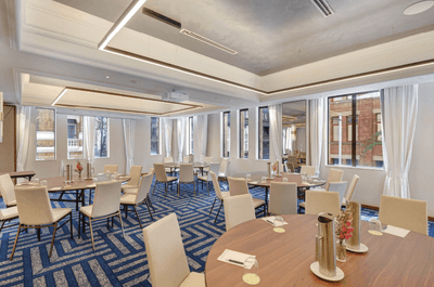 Pinaroo featuring wood round tables and chairs placed around the space on a blue carpet at The Grace Sydney