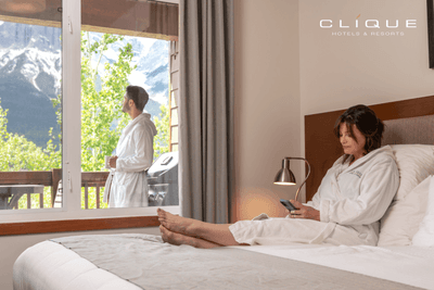 Relaxed couple enjoys their suite at Falcon Crest Lodge one looks at the mountain view from the balcony