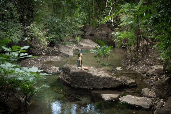 Lady sitting on a rock by the River at Hotel Rio Perdido